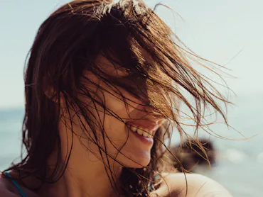 Self-portrait photo of a young woman at the beach.