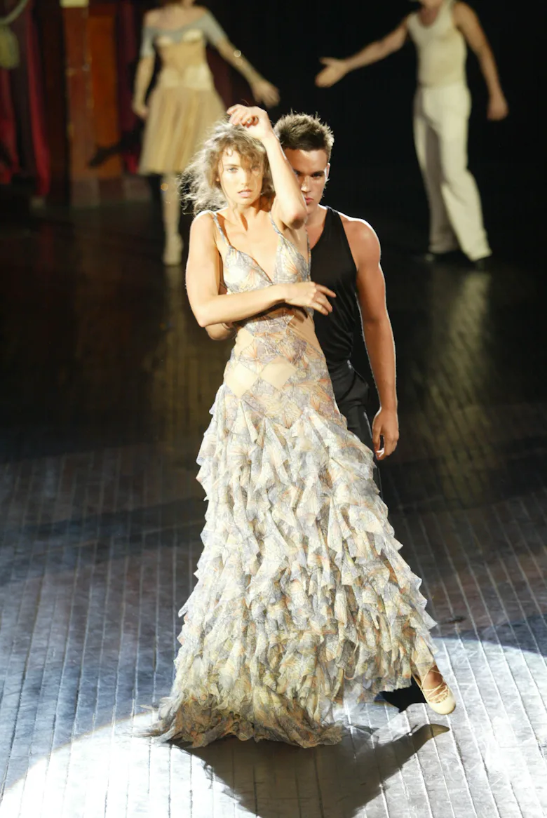 A model dances down the runway at the Spring 2004 Alexander McQueen show in Paris. (Photo by Giovann...