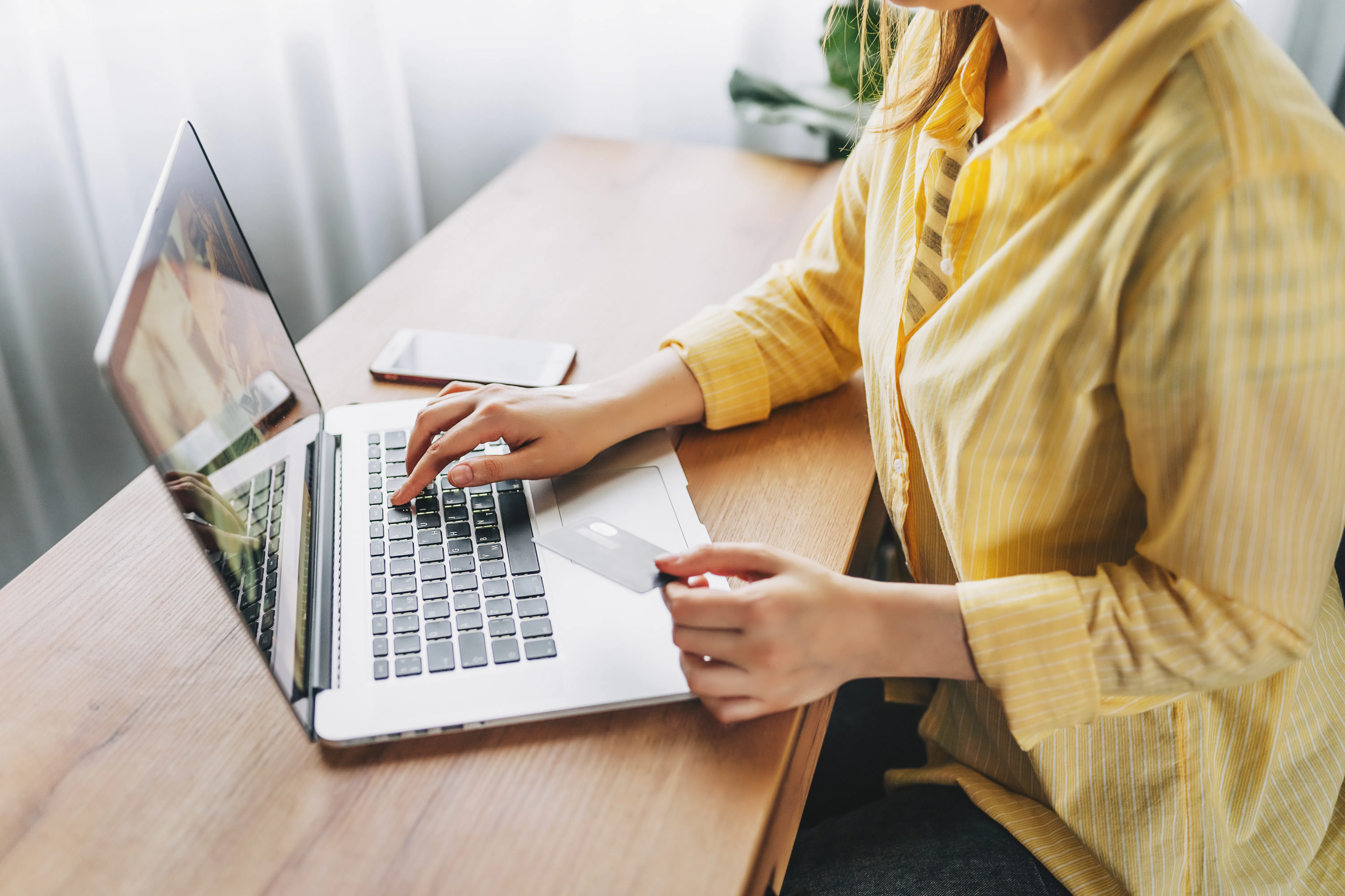 Shot of pretty young woman shopping online with credit card and laptop while sitting on the floor at...