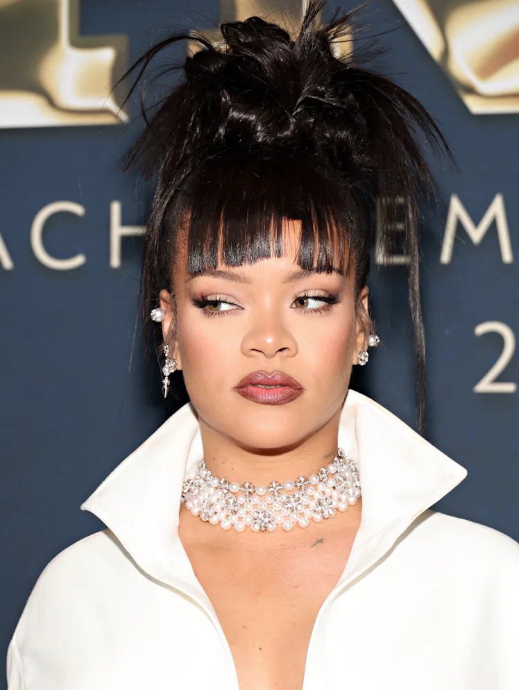 Rihanna with bangs and a spiky updo