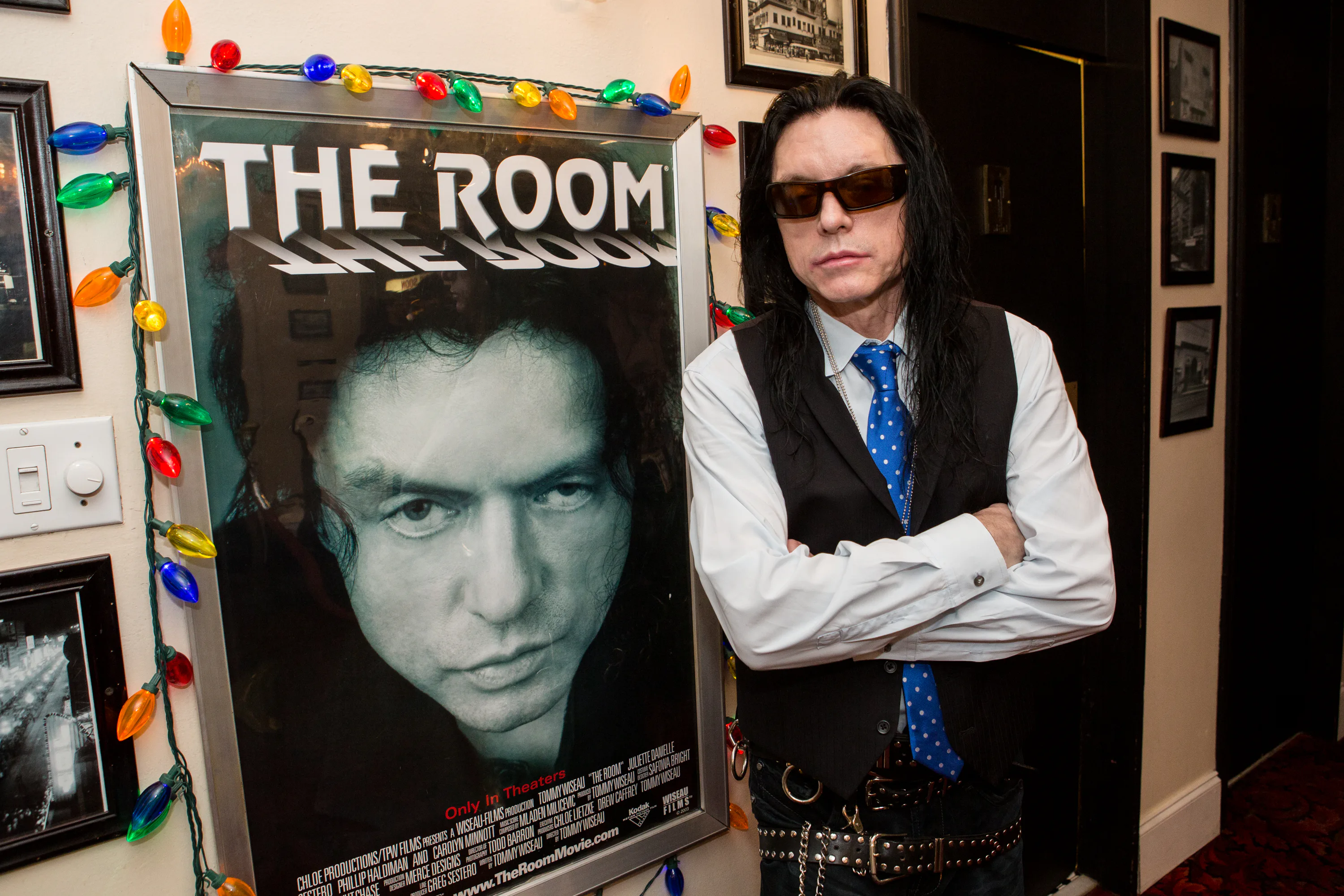 NEW ORLEANS, LA - DECEMBER 05:  Tommy Wiseau poses next to a poster for 'The Room' at 'The Room' scr...
