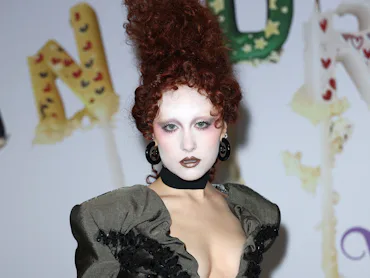 Chappell Roan with her hair piled up into a fantastical red updo at a Vivienne Westwood show