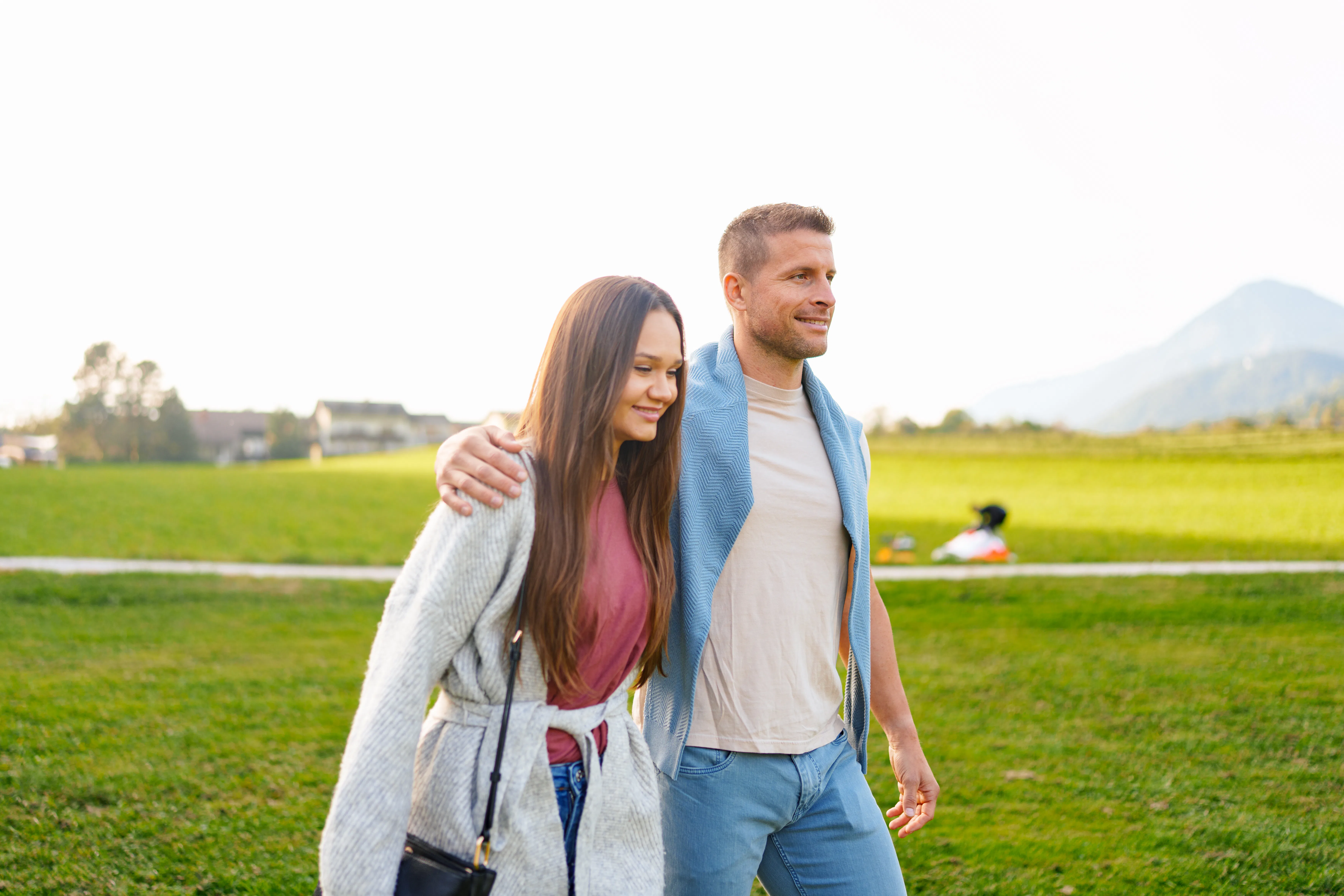 Caucasian couple walking together through a lush green meadow, enjoying the outdoor nature. a clear ...