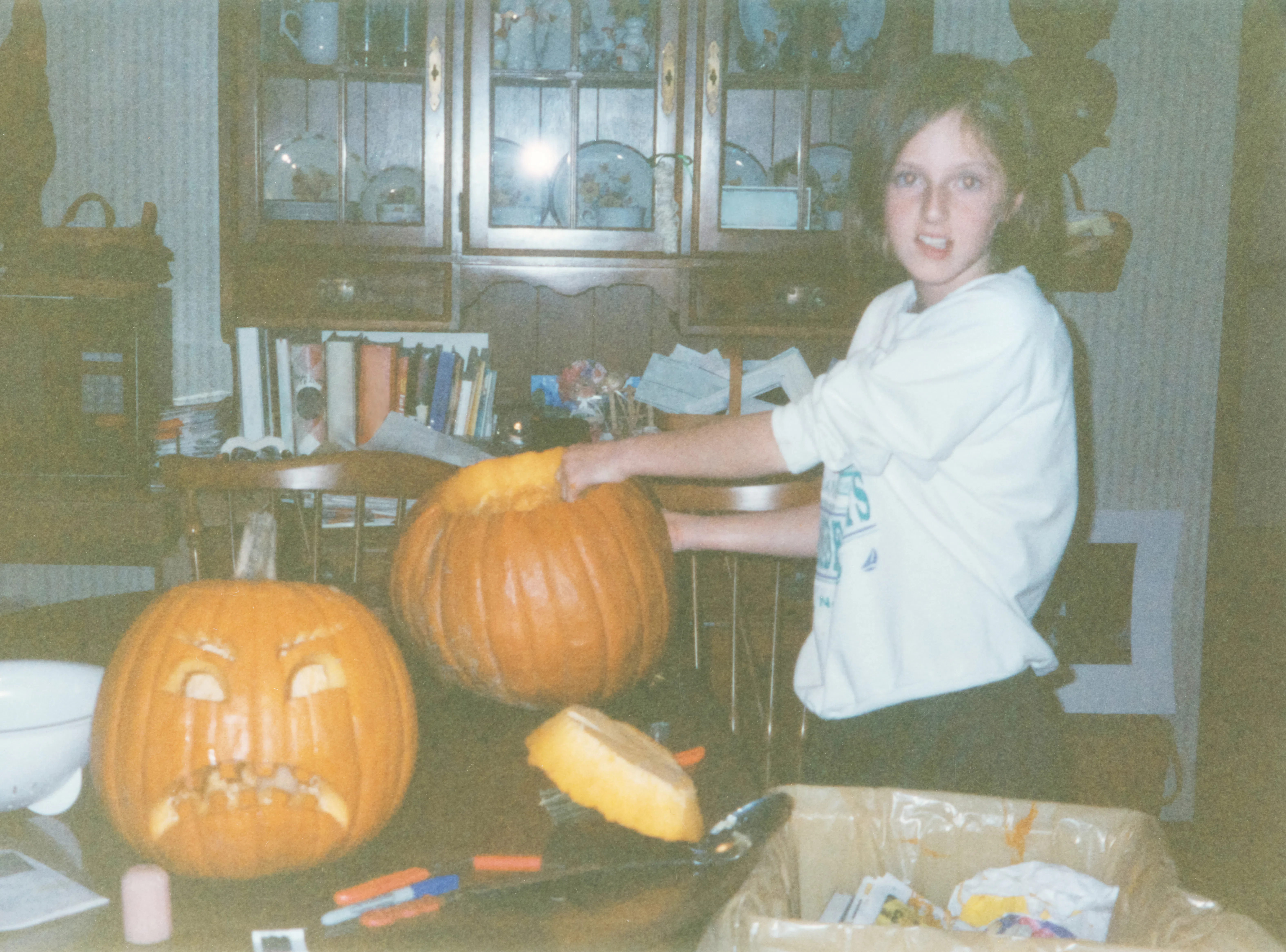 Vintage 90s kid carving pumpkin for Halloween. 1990s childhood concept for nostalgia, memories, or h...
