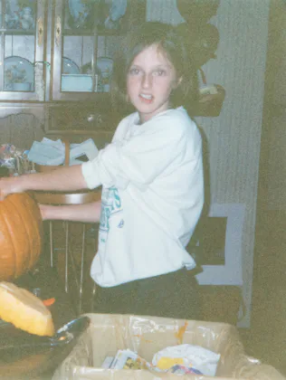 Vintage 90s kid carving pumpkin for Halloween. 1990s childhood concept for nostalgia, memories, or h...