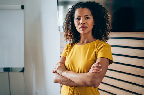 Shot of beautiful african-american businesswoman standing with crossed arms and looking at camera.