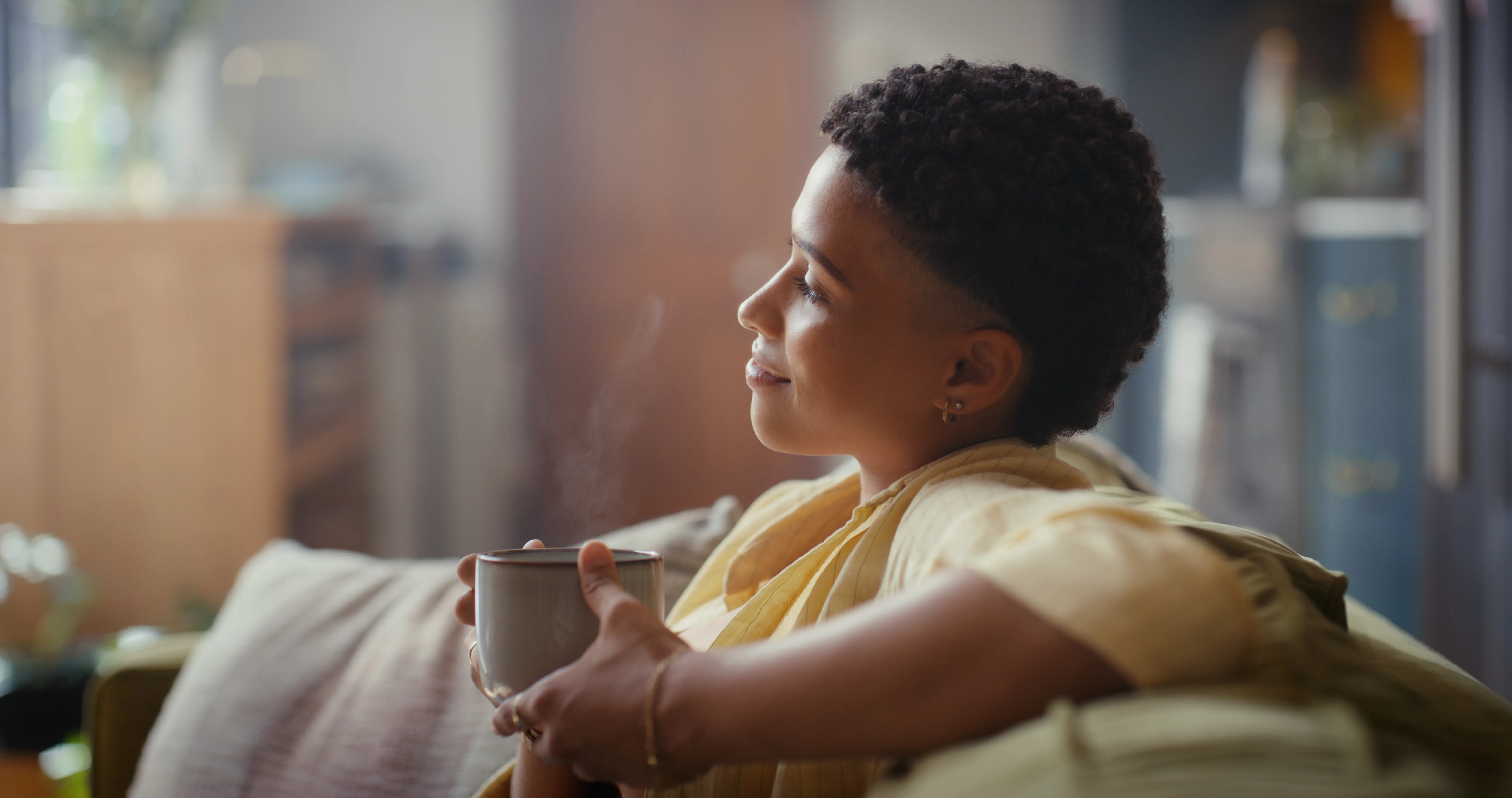 Thinking, smile or woman on sofa with coffee, happy memory or chill moment on weekend break. Reflect...