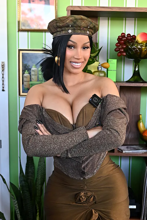 Cardi B at Beautycon in Los Angeles, wearing a hat, her arms folded