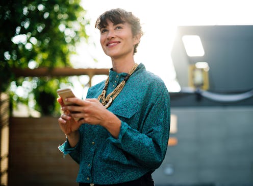 Female CEO smiling while typing on her phone