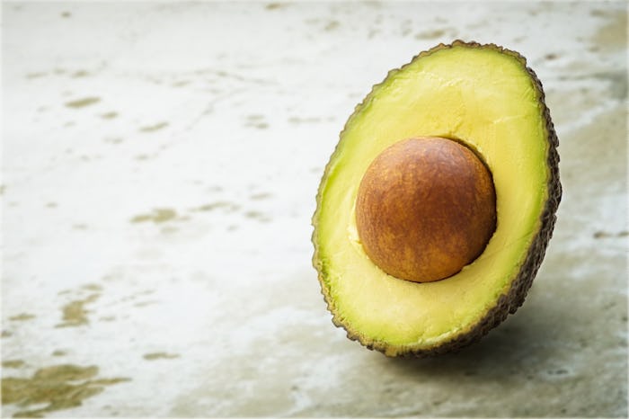 A halved avocado placed on the ground