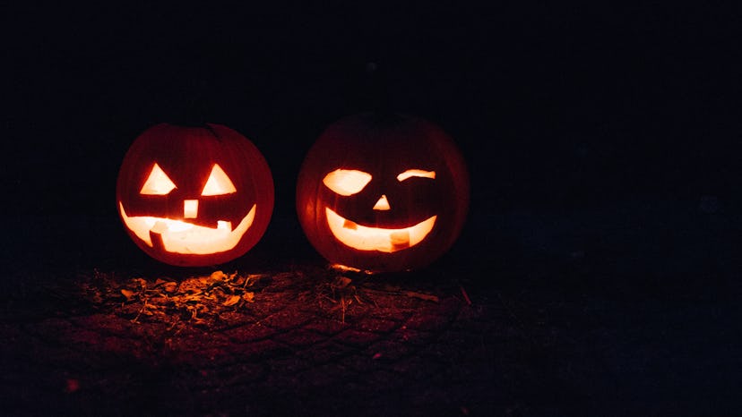 Two pumpkin lanterns photographed during the night, with light inside them