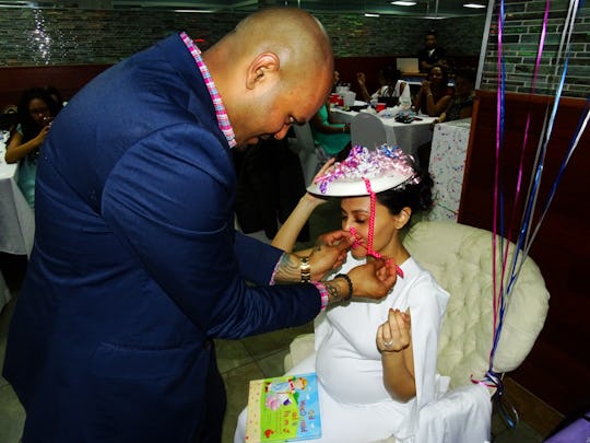 Husband helping his wife tie up her hat string while at her birthday party