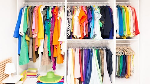 A perfectly organized wardrobe with colorful clothes on hangers