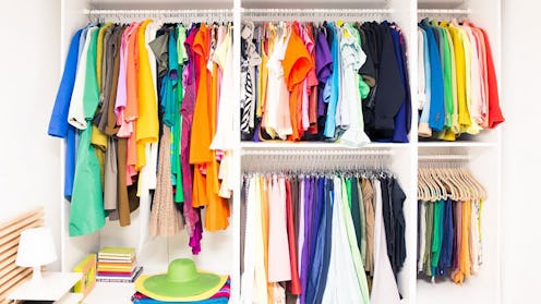 A perfectly organized wardrobe with colorful clothes on hangers