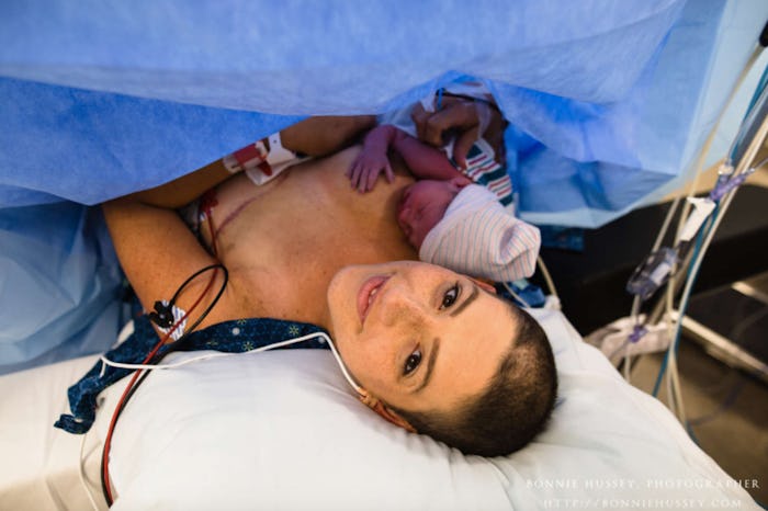 A mother with breast cancer lying with her newborn baby