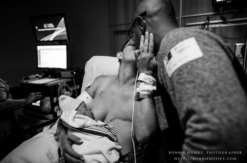 A woman who gave birth while battling breast cancer breastfeeding her baby and kissing her husband w...