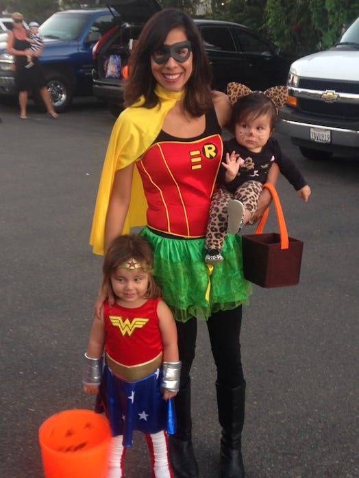 Ambrosia dressed in a women’s Robin Costume, with her daughters dressed in Wonder Woman and kitten c...