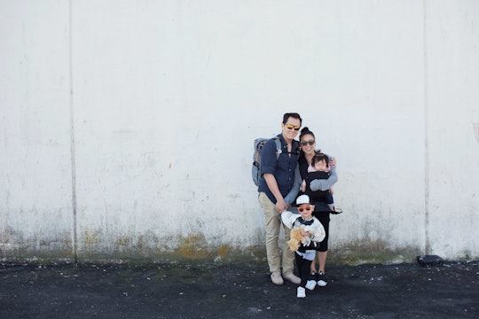 Irene Lee with her husband and her children posing next to a white wall