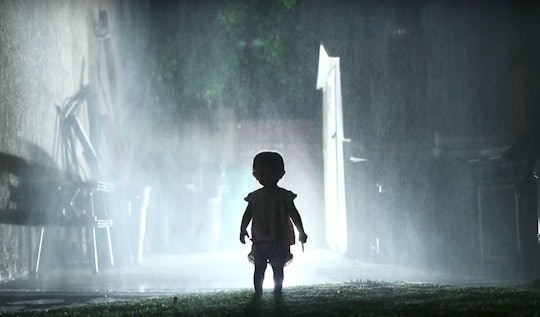 Horror movie scene where a baby is walking down a street alone on a rainy night