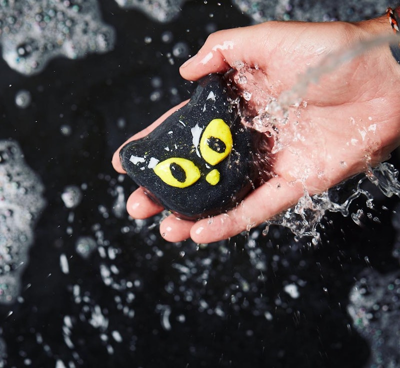 A hand holding the new halloween lush bubble bar shaped like a black owl with yellow eyes