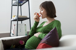 A woman with asthma using an inhaler due to possible serious pregnancy comptications