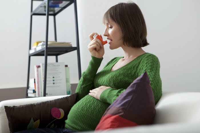 A woman with asthma using an inhaler due to possible serious pregnancy comptications