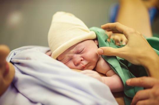 A mother lying in a hospital bed with her newborn baby after giving birth