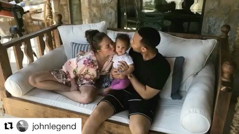 Chrissy and John kissing their daughter