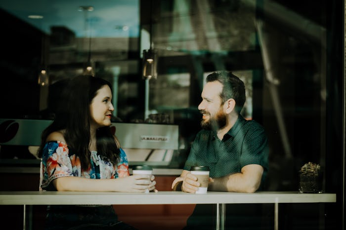 Two business partners sitting together and having a coffee at a coffee bar
