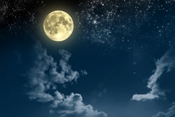 The night sky with clouds, stars and a bright yellow full moon in Aries