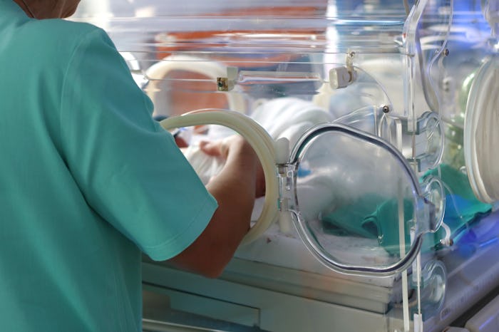 A nurse checking a prematurely born baby in an incubator in The United States