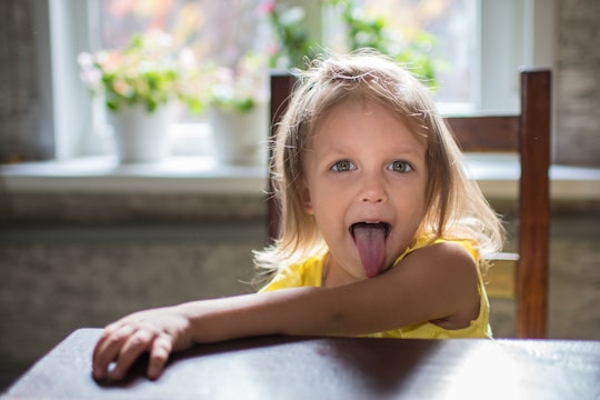 A young daughter posing with her tongue out