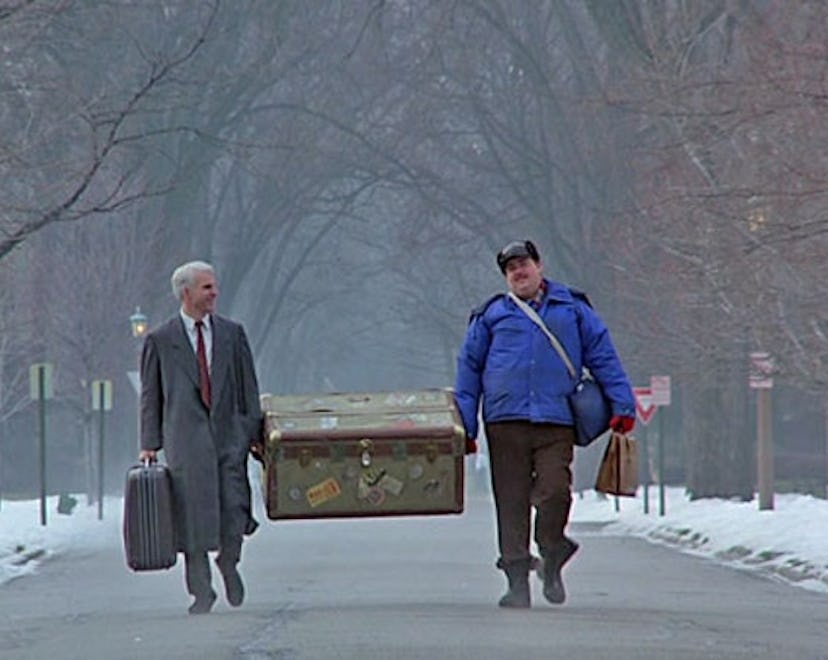 Two men carrying a big box down a road in "Planes, Trains, and Automobiles" Thanksgiving movie