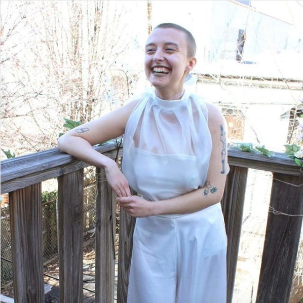 A young short-haired lady posing for a photo on a balcony