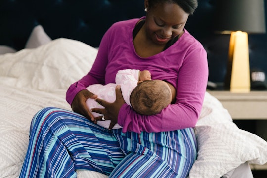 A breastfeeding support worker breastfeeding a newborn baby
