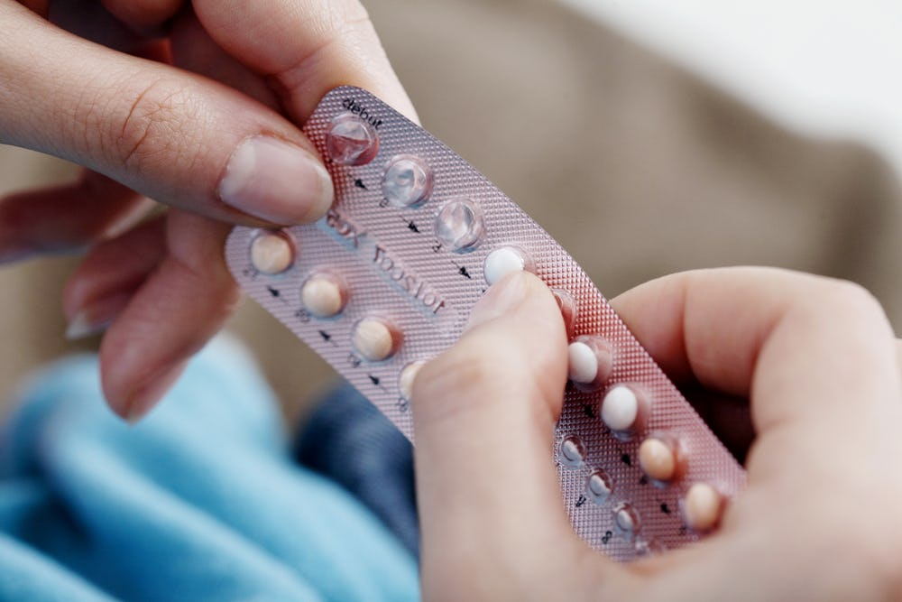 A woman holding a birth control pill package