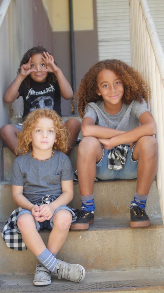 Three kids sitting on small stairs