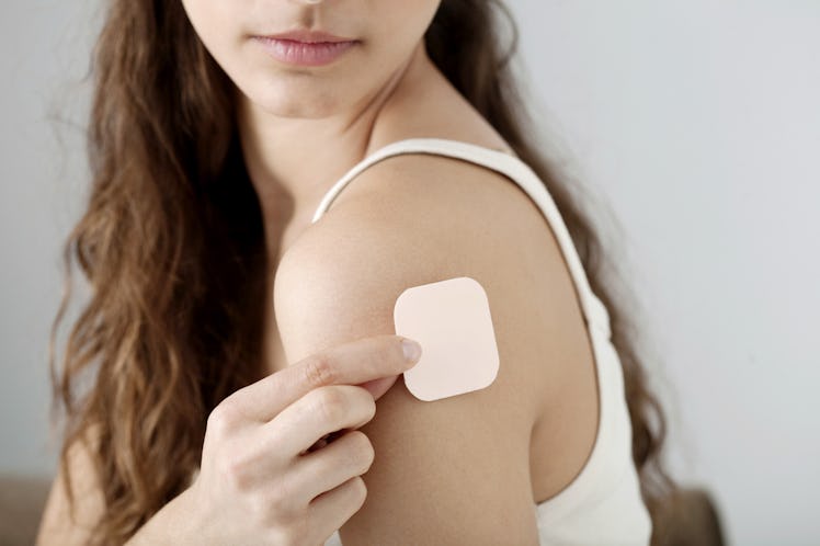 Woman putting on a transdermal contraceptive patch