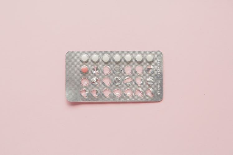 Birth control pills on a pink background