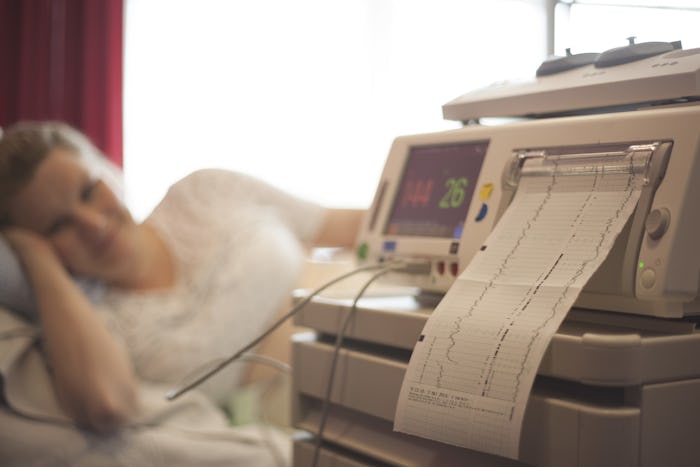 A woman in labor lying in a hospital machine giving brain health results