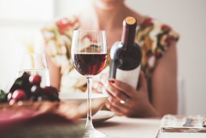 woman eating holding bottle of wine