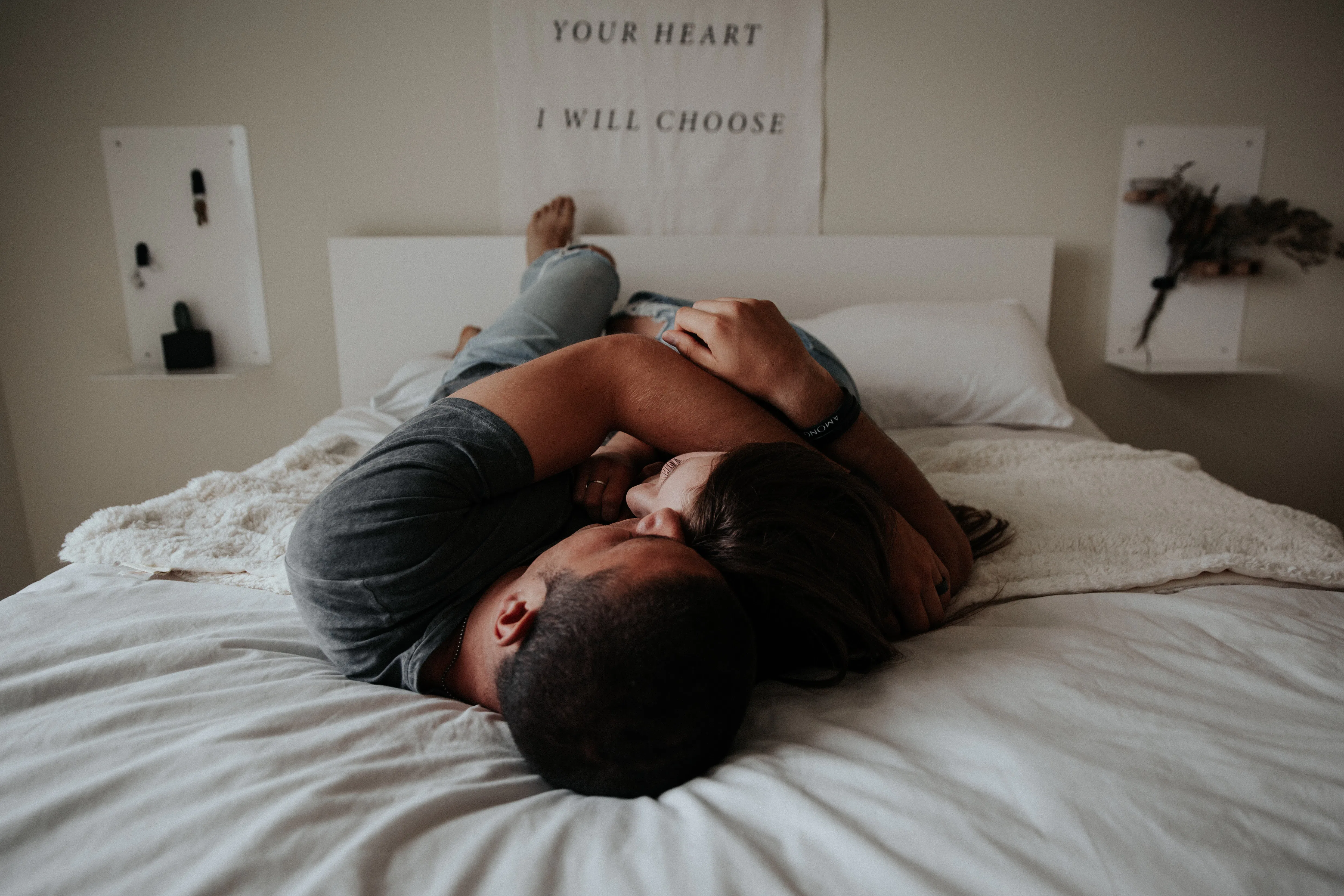 A man and woman lying in bed about to get intimate with a smart "condom"