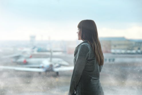 A woman waiting at an airport, looking at planes landing on thanksgiving