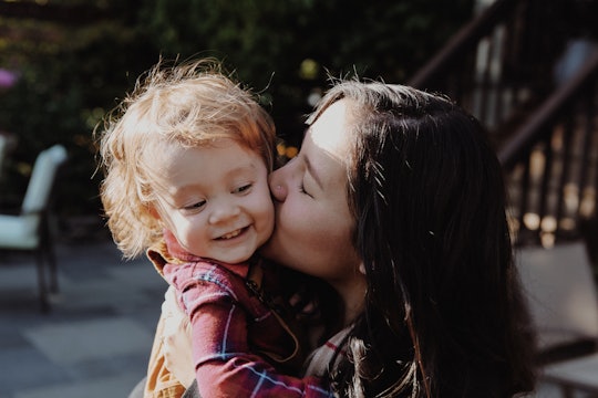 Working mom kissing her daughter