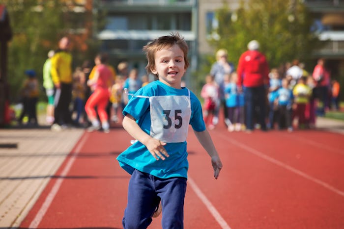 A little kid running in a race and losing with a smile on their face