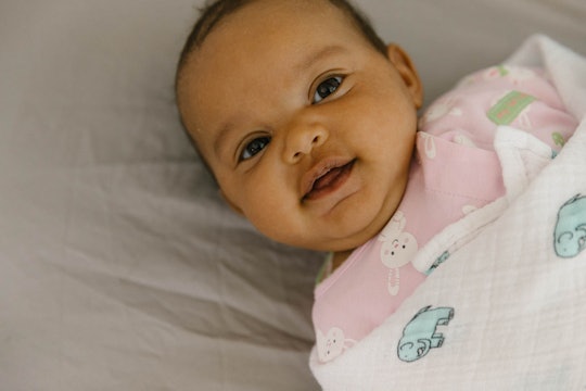 Little baby girl lying on a bed, smiling