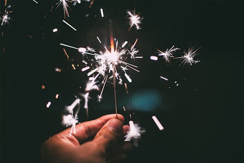 A hand holding a sparkler on New Year's Eve