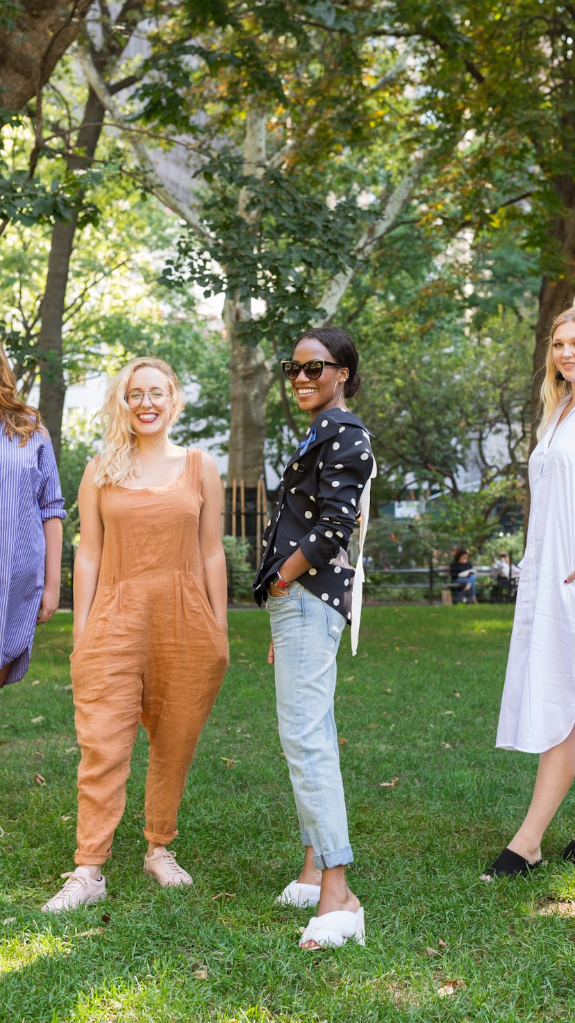 Women standing on a lawn posing and smiling at the camera.