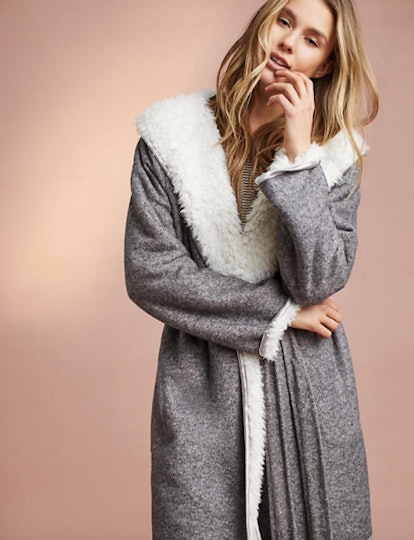 A young blonde female wearing a cozy Anthropologie robe in grey