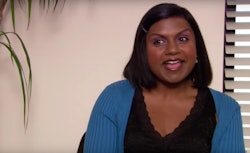 Mindy Kaling in a black shirt and blue sweater in 'The Office'